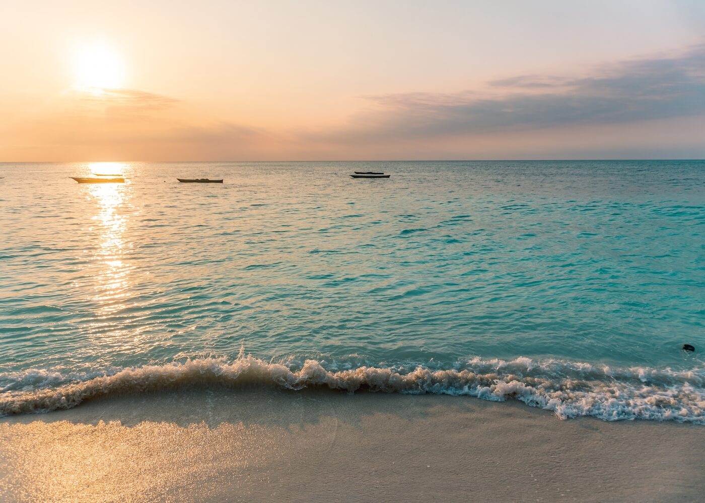 Nungwi, Zanzibar. Beautiful Sunset At The Beach In Tanzania, Africa. Turquoise Sea, Orange Sky. Fishing Boats In The Horizon.